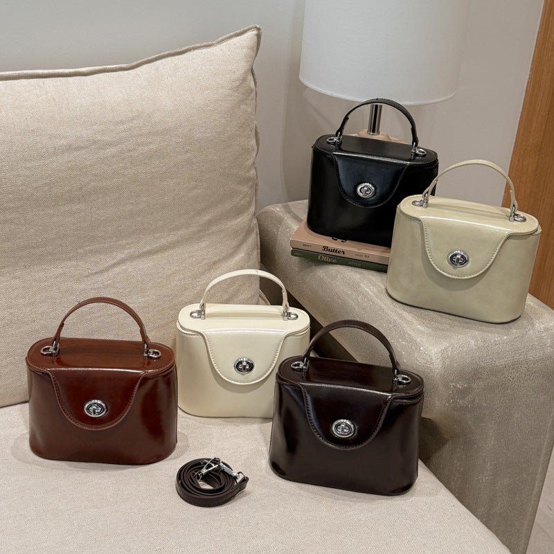 Damen Mini-Handtasche im elegant geschwungenen Design mit spielerischem Anhänger