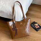Damen elegante Handtasche aus hochwertigem Kunstleder mit verspieltem Anhänger