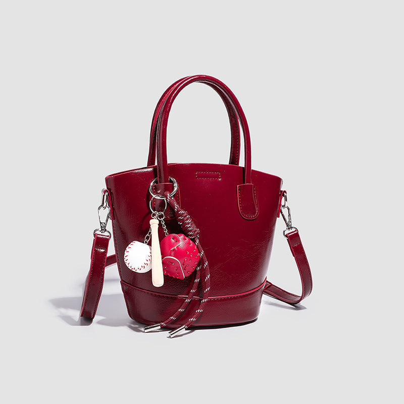 Damen Mini Tasche mit glänzender Oberfläche und verspieltem Anhänger