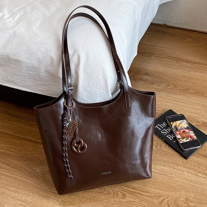 Damen elegante Handtasche aus hochwertigem Kunstleder mit verspieltem Anhänger